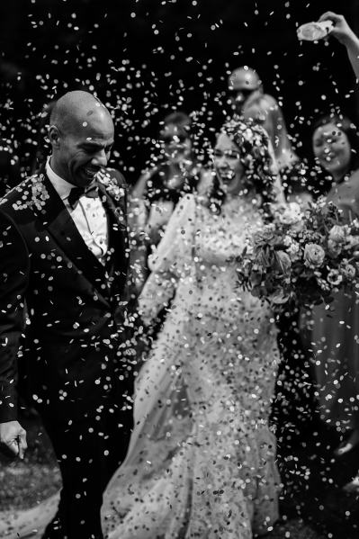 Black and white image of couple covered in confetti