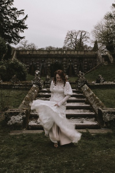 Bride twirls and swirls on bridal gown/dress garden setting beside steps