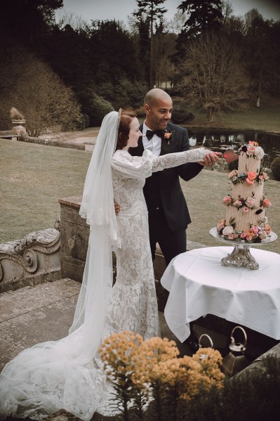 Bride and groom cut the wedding cake together with a knife