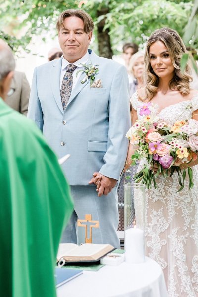 Priest speaks to bride and groom and couple