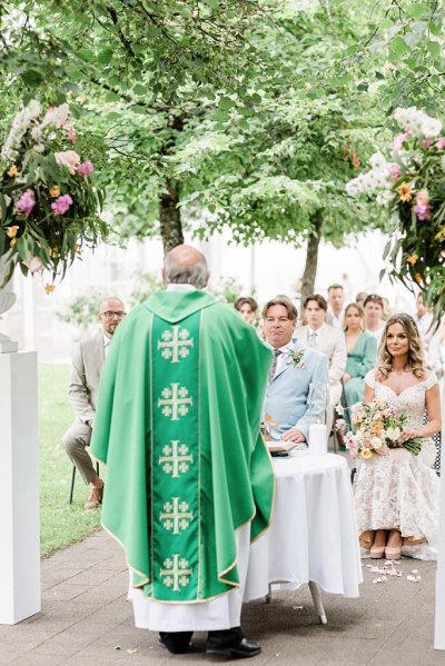 Priest speaks to bride and groom and couple