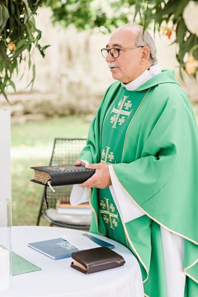 Priest in green holds bible