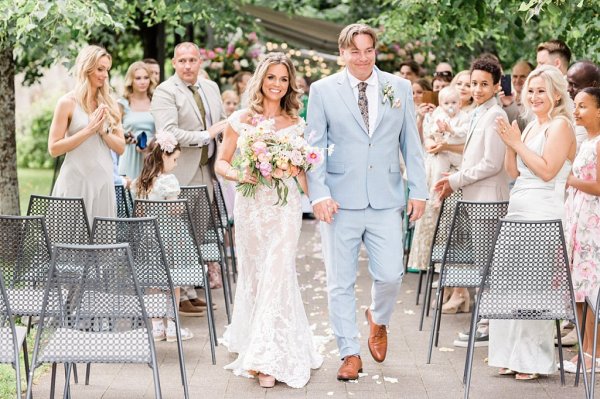 Bride and groom exit ceremony guests clap