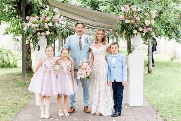 Bride groom little girls and boy outside family portrait