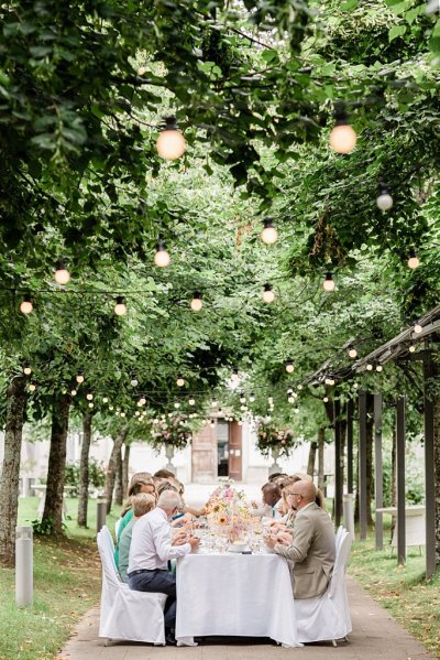 Guests seated forest park setting trees surrounding them lights