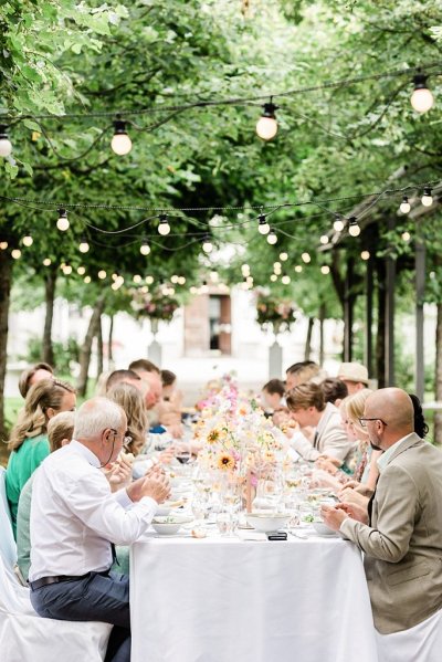 Guests seated forest park setting trees surrounding them lights