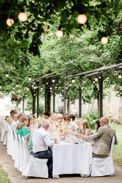 Bride and groom raise their wine glasses red and white guests