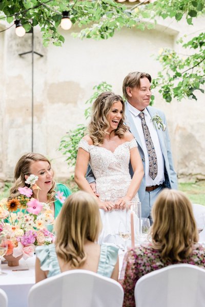 Bride and groom give speech laughing smiling