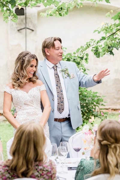 Bride and groom give speech laughing smiling