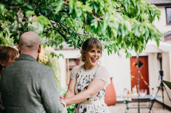 Bride and groom bound with ribbon during ceremony bride smiles towards guests