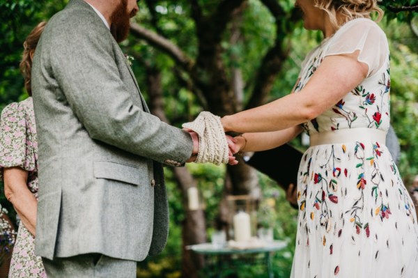 Bride and groom bound with ribbon during ceremony