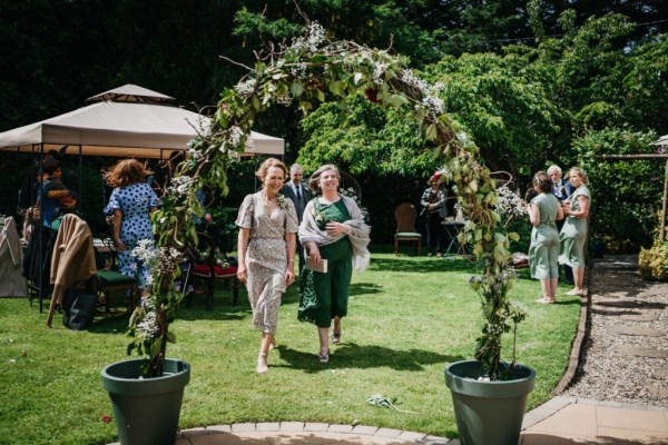 Women walking under flower bed in garden