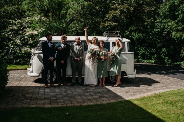 Bride and bridesmaids groom and groomsmen in front of white wedding van