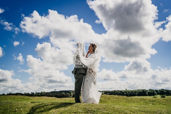 Skyline view behind couple bride and groom wind blowing veil couple