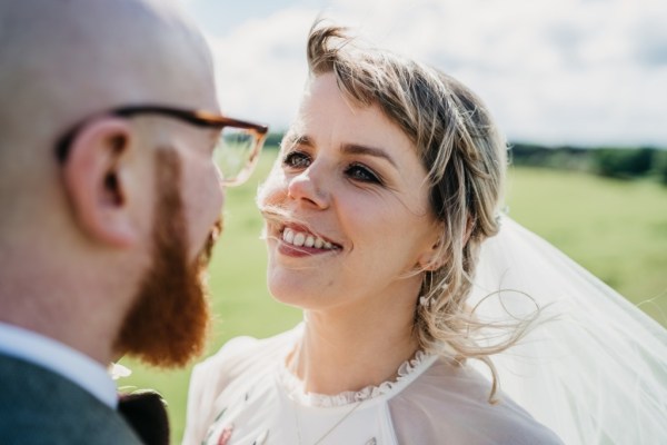 Bride smiling at groom wind blowing hair