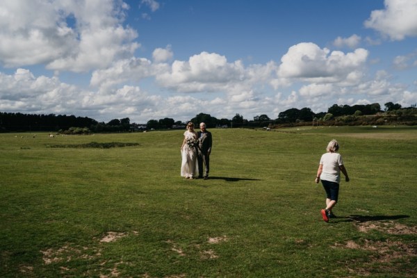 Bride and groom standing on grass together