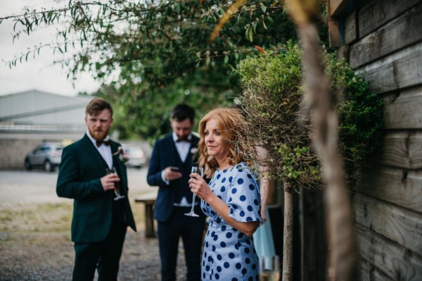 Woman in polka dot blue dress drinks wine