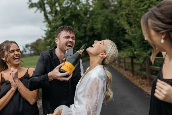 Bride drinking champagne prosecco with man friend