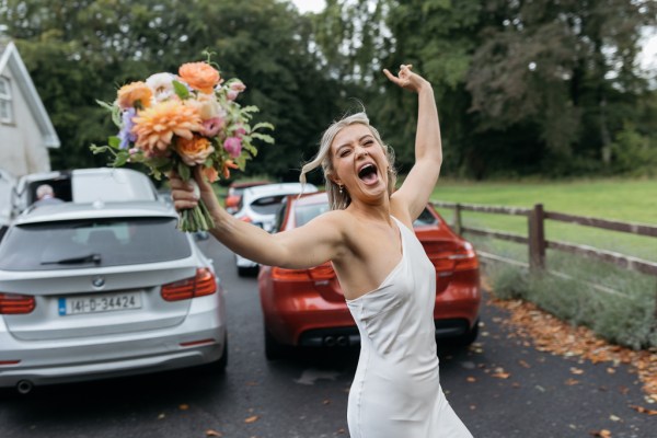 Bridesmaid bouquet in air smiling celebrating