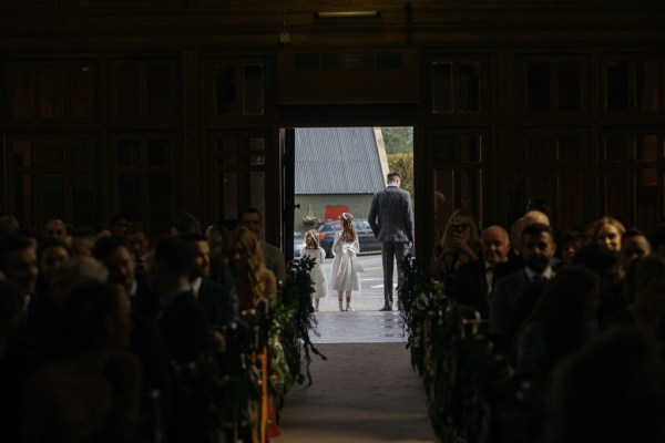 Dark photo of guests seated inside church