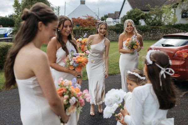 Two little girls and bridesmaid holding bouquets