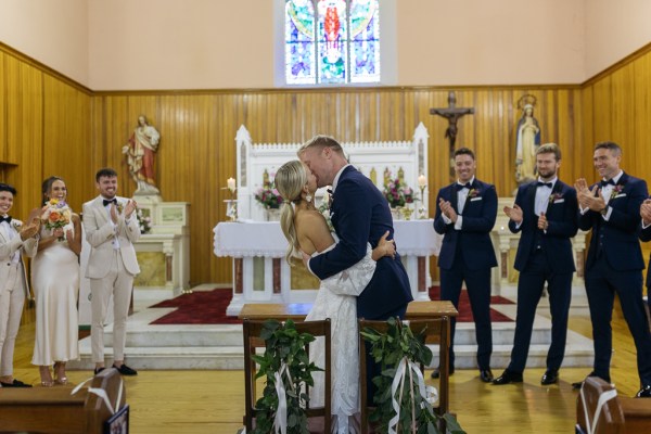 Bride and groom at the alter to church kissing