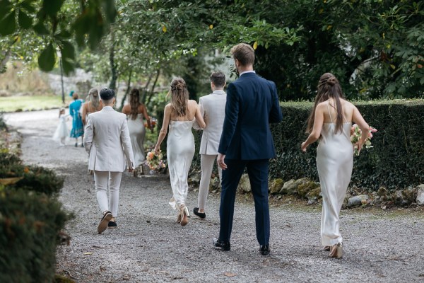 Bridesmaids and men walk towards wedding venue