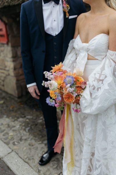 Close up on bouquet detail orange flowers bride and groom