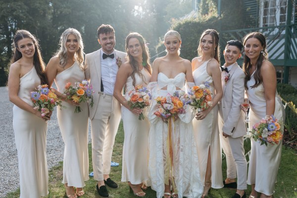 Groom bride and her bridesmaid pose for a picture