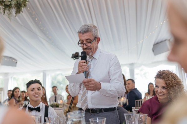 Father gives speech as he speaks into microphone