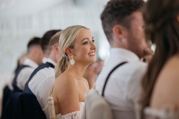 Bride and groom sit and smile at table