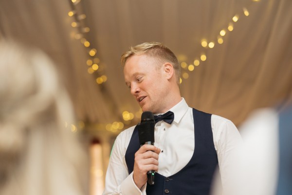 Groom gives speech speaks into microphone