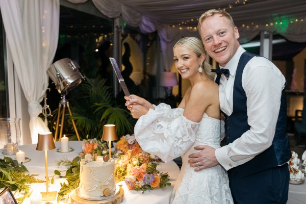 Bride and groom cut the wedding cake together