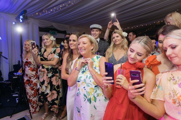 Friends and guests take pictures of the happy couples first dance