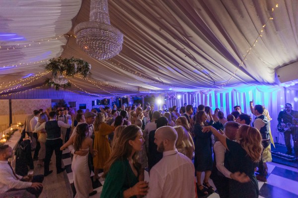 Chandelier detail over guests as they dance on the dancefloor