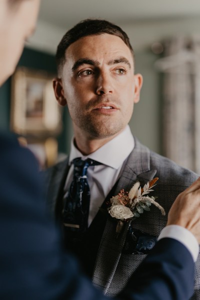 Groom ready in suit flower pinned to jacket