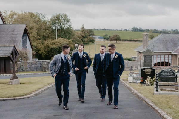 Groom and groomsmen walking along pathway