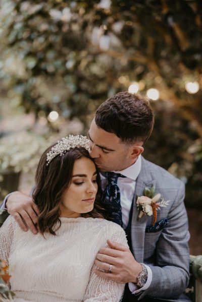 Groom kisses bride on the head