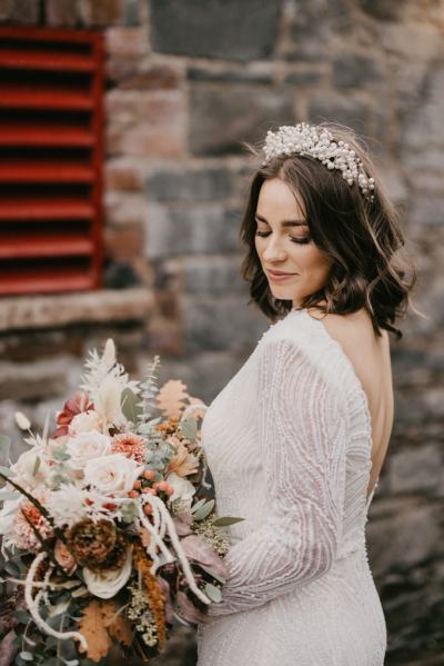 Bride looks down close up of flowers exterior shot