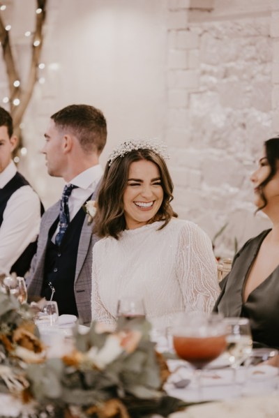 Bride and groom laugh smiles with guests bridesmaid