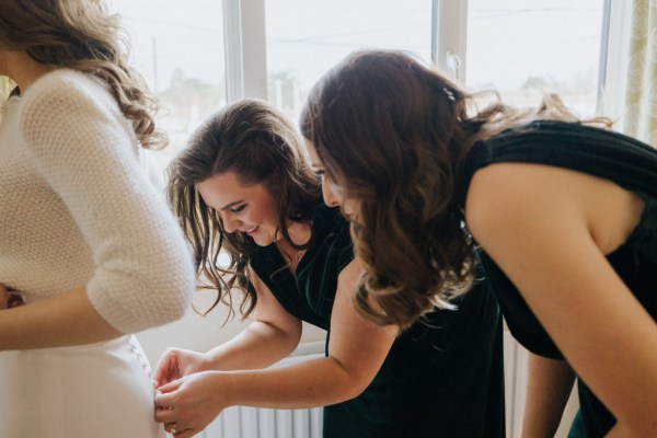 Bridesmaids helping bride get ready