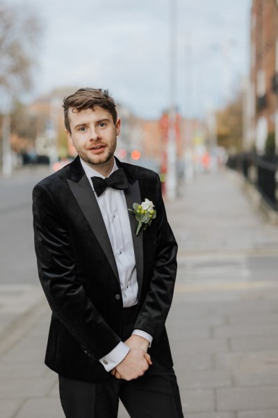 Groom standing on his own in street