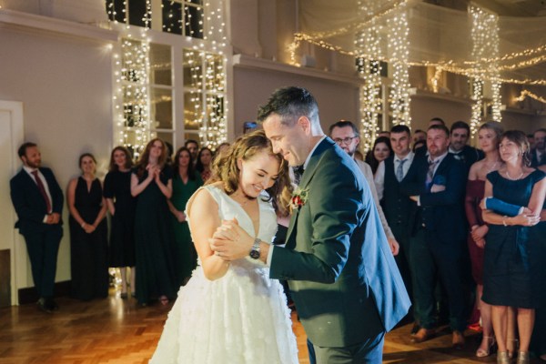 Bride and groom dancing on the dancefloor surrounded by guests