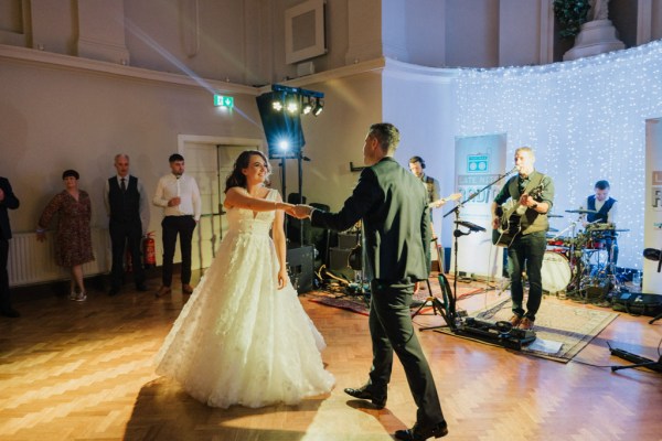 Bride and groom dancing on the dancefloor surrounded by guests