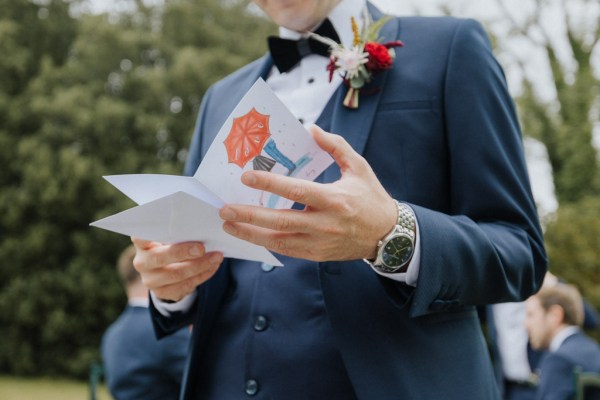 Groom close up reading card detail vows