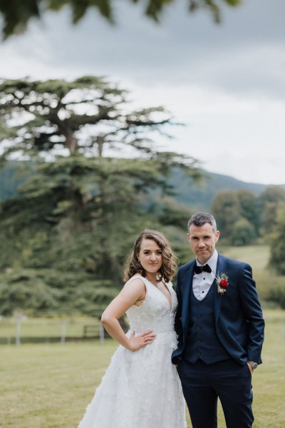 Bride and groom face the camera garden forest setting farm