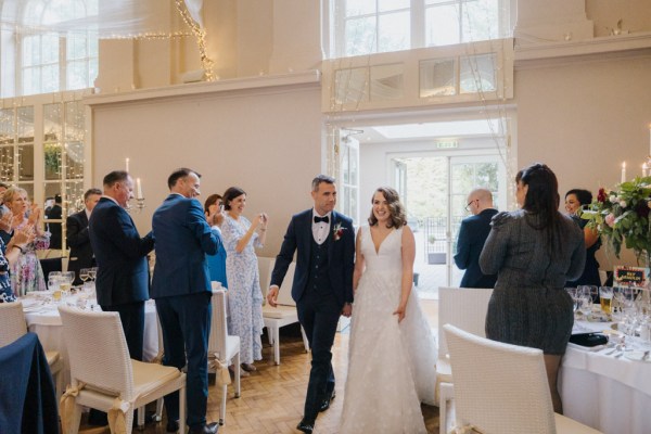 Bride and groom exit ceremonial room hand in hand