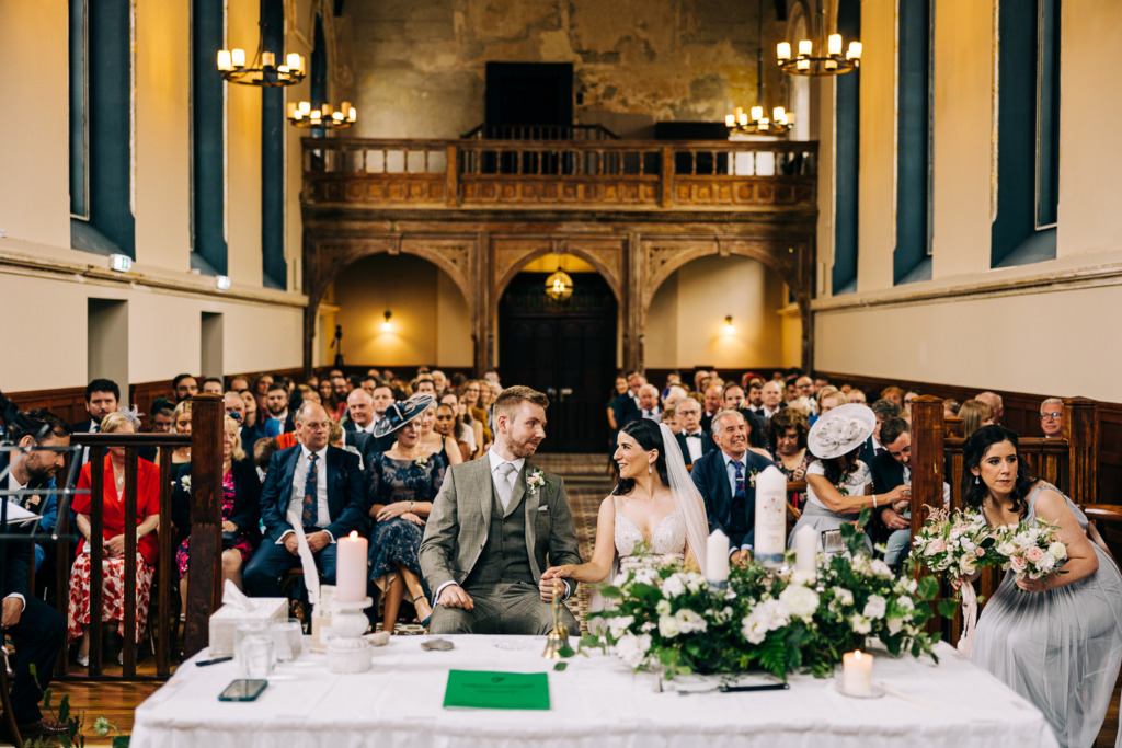 Bride and groom laugh at the alter