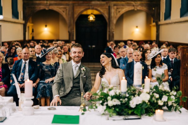 Bride and groom laugh at the alter