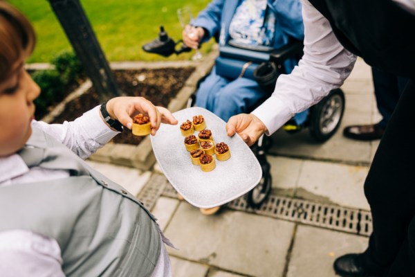 Waiter offering food to guests canape food